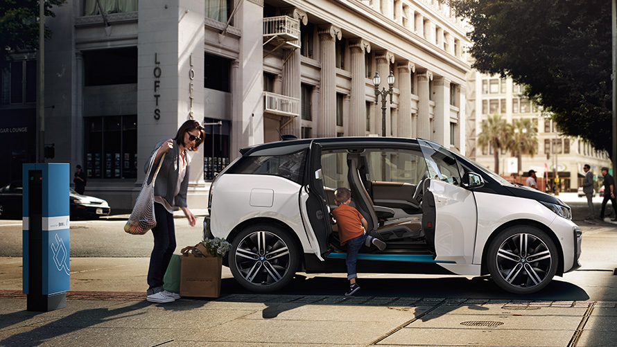 BMW i3 in een stedelijke omgeving BMW rijbereik BMW i3 in een stedelijke omgeving met vrouw en kind
