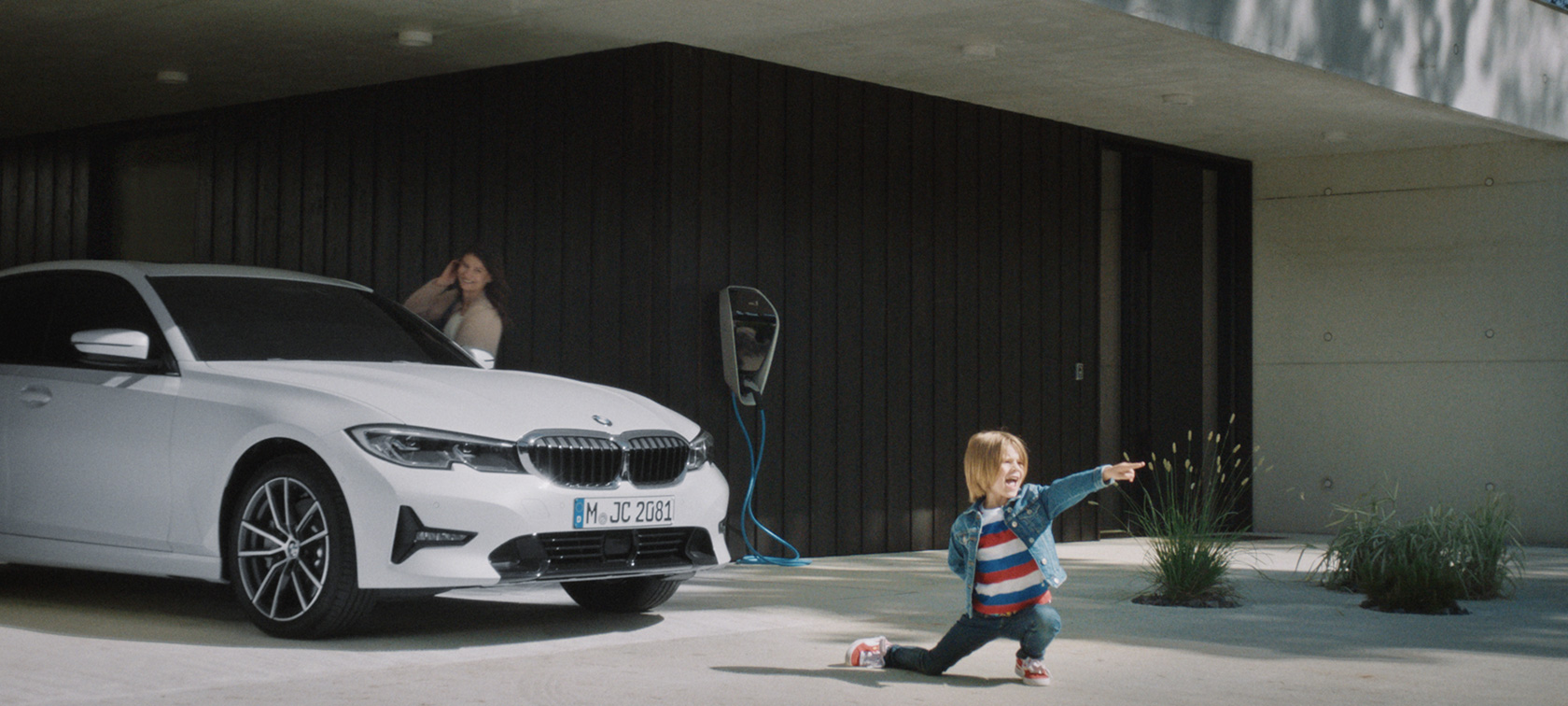 BMW hybride wagen aan laadstation BMW plug-in-hybride Jongen voor BMW hybride wagen aan laadstation