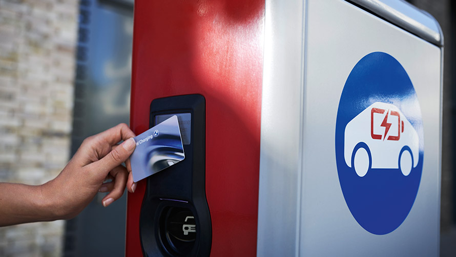 Publiek opladen met BMW Charging Card Persoon houdt BMW Charging Card aan openbaar laadstation