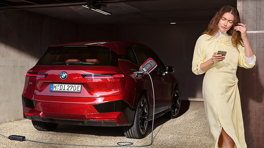 Connected Charging in de My BMW App Connected Charging in de My BMW App BMW i7 xDrive60 ladend met persoon op de voorgrond