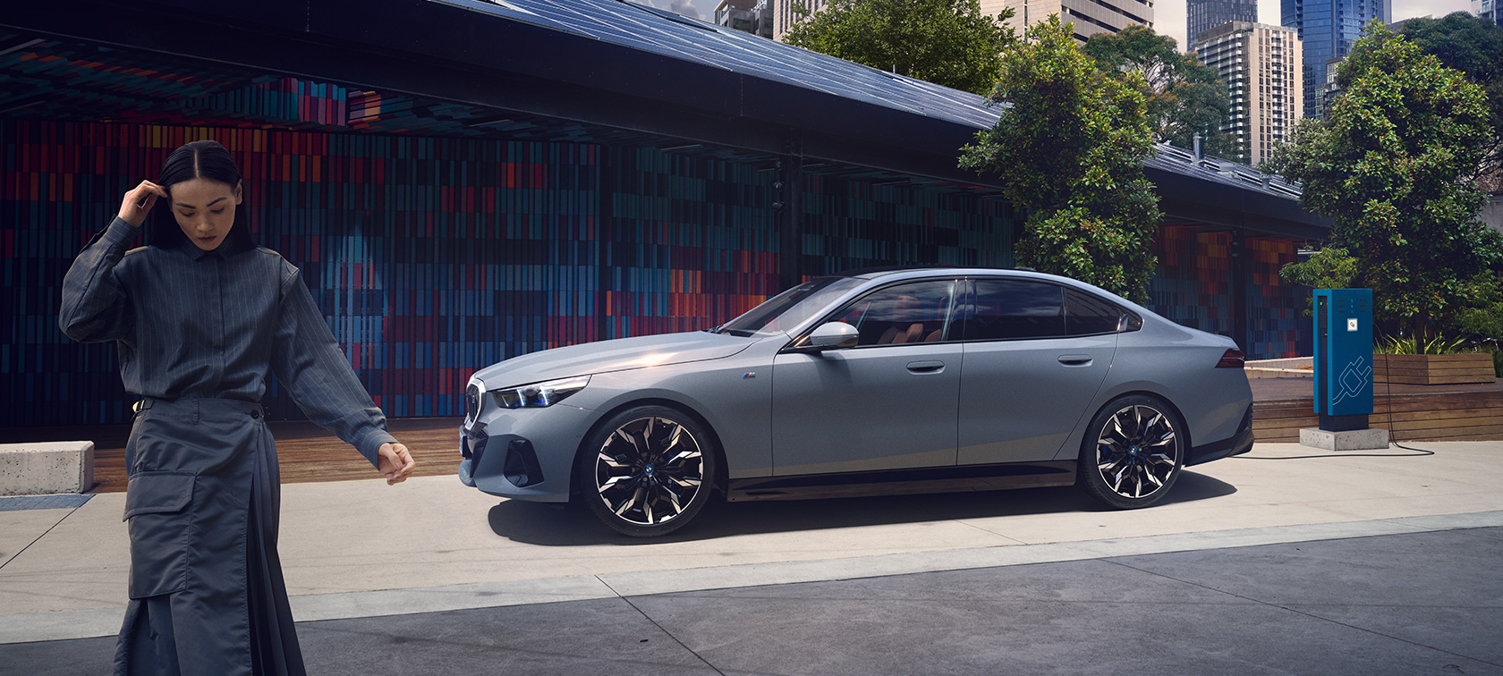 BMW i5 G60 zijaanzicht laadsituatie BMW i5 G60 zijaanzicht met vrouw laadsituatie