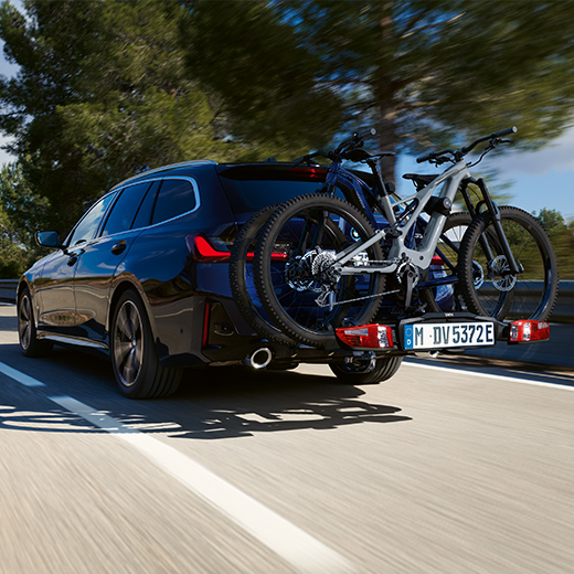 BMW 3 Reeks Touring G21 PHEV 3/4 achteraanzicht met fietsen rijdend