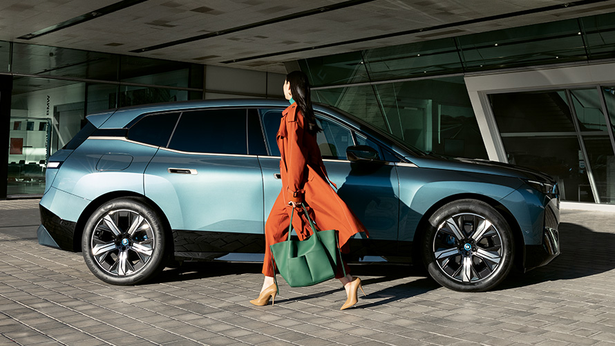 BMW Digital Key voordelen BMW Digital Key voordelen BMW iX i20 zijaanzicht met vrouw op de voorgrond