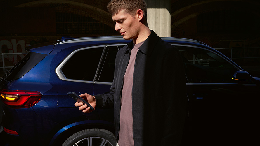 BMW Digital Key – tot vijf gebruikers instellen BMW Digital Key instellen voor maximaal vijf gebruikers man met smartphone voor BMW X5.