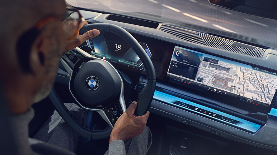 BMW interieur man kijkt op display met Operating System 8.5 BMW interieur man kijkt naar BMW Maps op display met Operating System 8.5