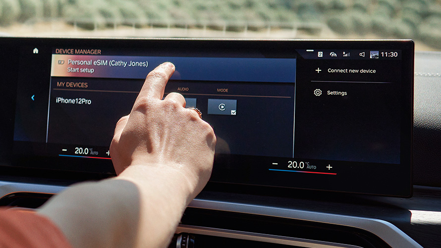 Persoon gebruikt Personal eSIM op het Control Display van de BMW iX met aanraakbediening Persoon gebruikt Personal eSIM op het Control Display van de BMW iX met aanraakbediening