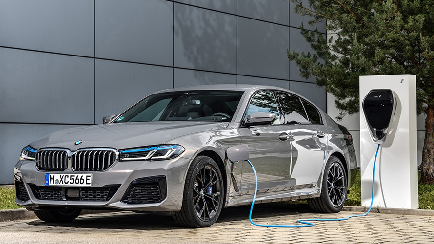 BMW Remote Software Upgrade véhicule BMW hybride à une borne de recharge BMW Remote Software Upgrade véhicule BMW hybride à une borne de recharge vue de trois quarts avant