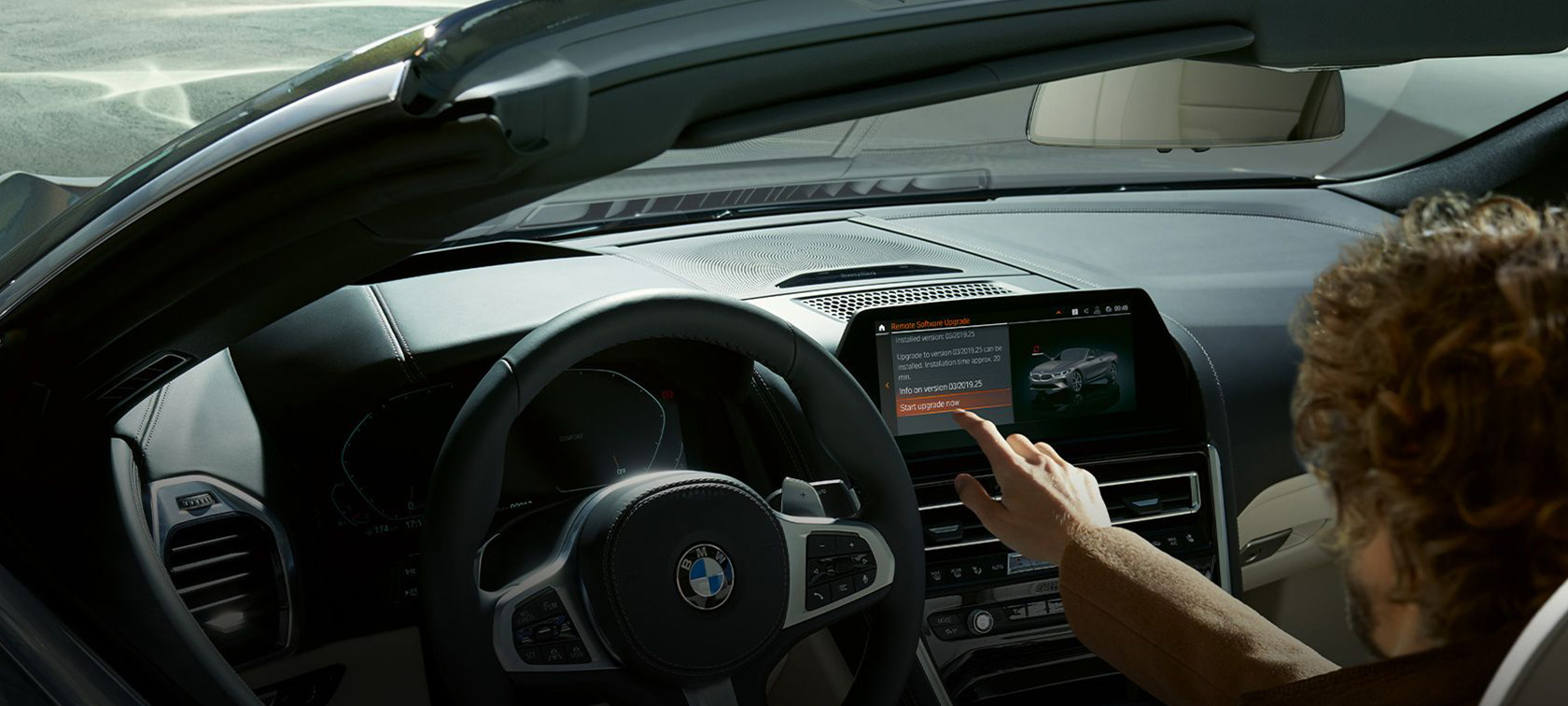 BMW Remote Software Upgrade Un homme est assis à bord d’une BMW et démarre le BMW Remote Software Upgrade