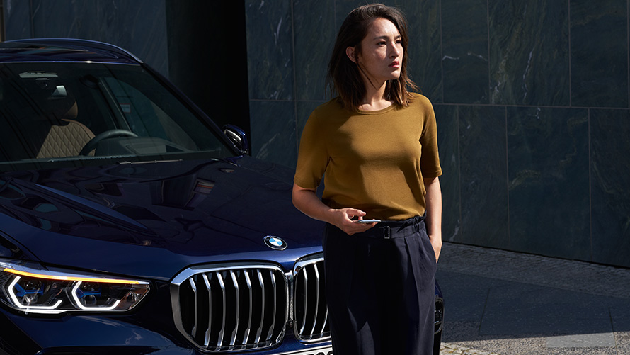 Service et dépannage Une femme est assise devant une BMW rouge et utilise l'assistance Service et dépannage.