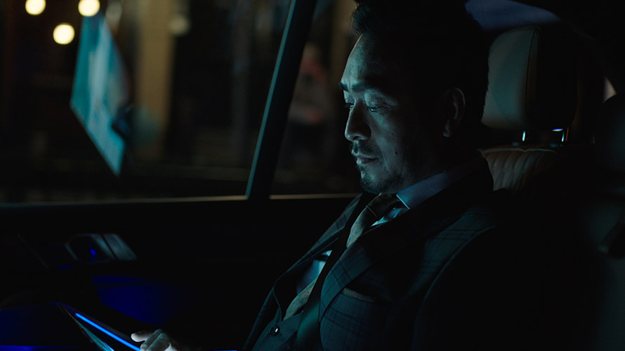 Modes Experience Un homme est assis sur le siège arrière d'une BMW et utilise les modes Experience sur son smartphone.
