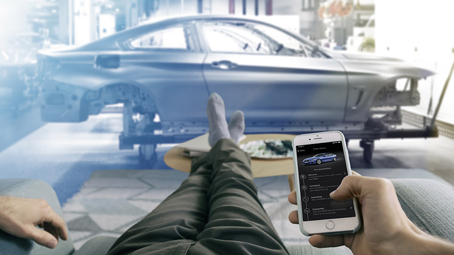 My Car Is Born Un homme est allongé dans un fauteuil et utilise My Car Is Born sur son smartphone.