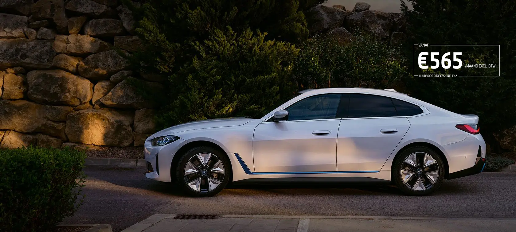 BMW i4 eDrive40 G26 2021 Mineralweiß driekwart vooraanzicht stilstaand aan meer met heuvels op de achtergrond